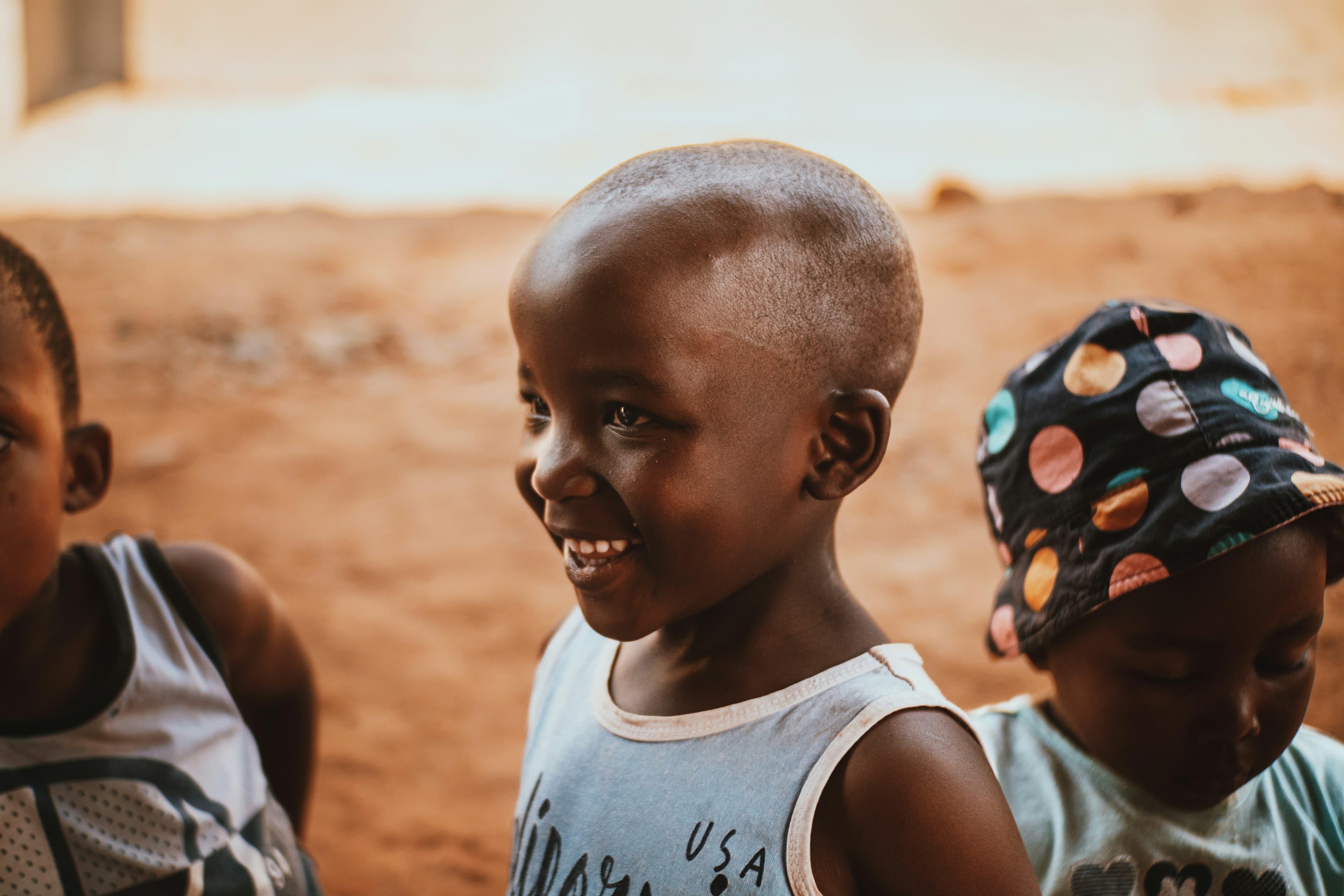 An African caregiver and young child together in a warm, dignified setting, illustrating protection, belonging, and care.